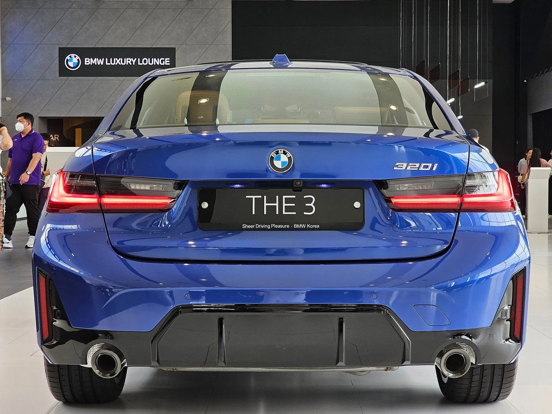 Traseira do BMW 320i M Sport azul com saídas de escape aparentes