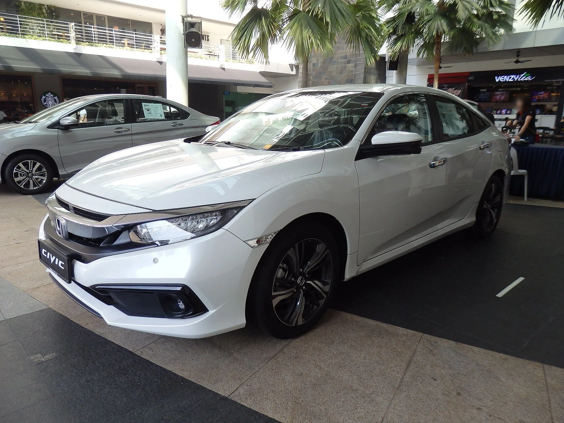 Honda Civic sedan branco de décima geração em showroom, vista dianteira três-quartos