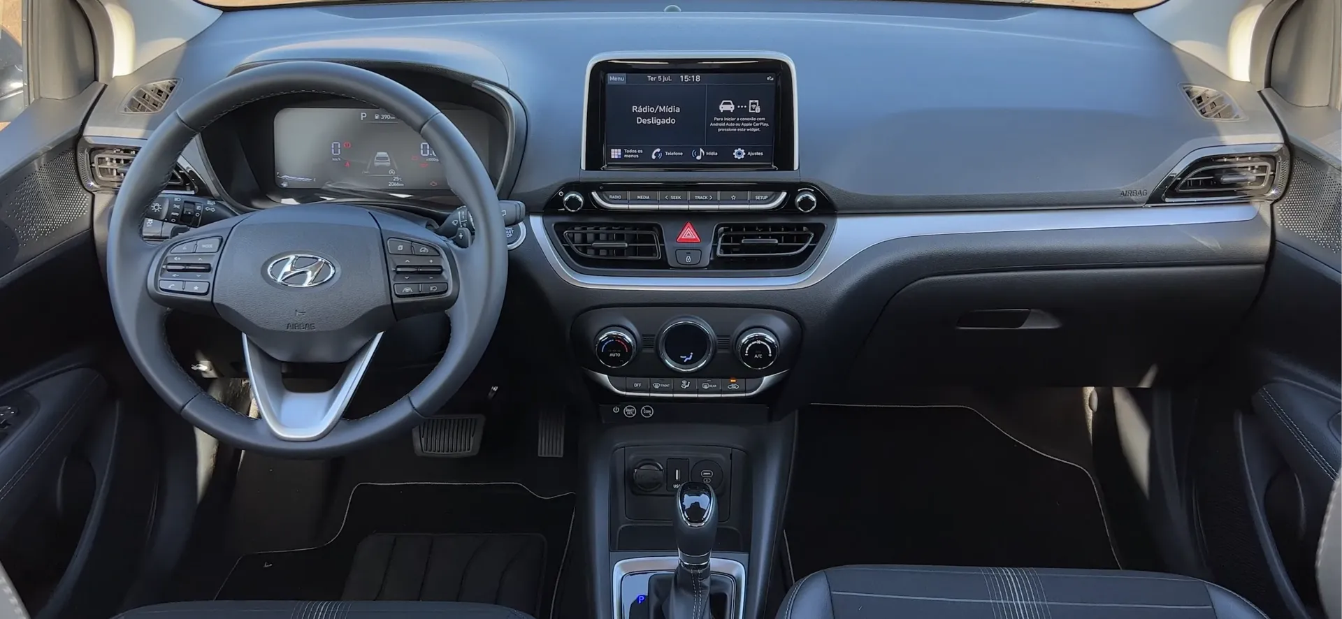 Interior do Hyundai HB20 com volante, central multimídia e console central