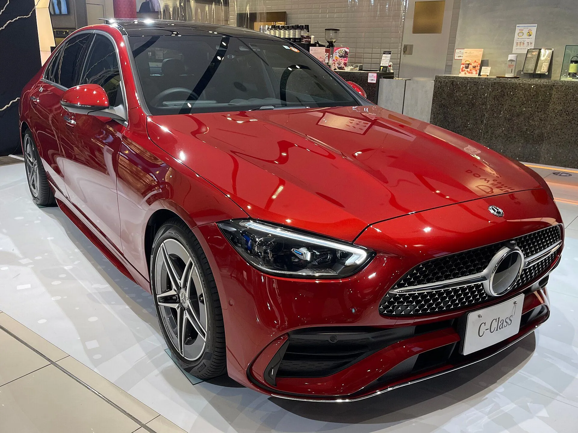 Mercedes-Benz C 200 vermelho de nova geração em showroom, vista dianteira três-quartos