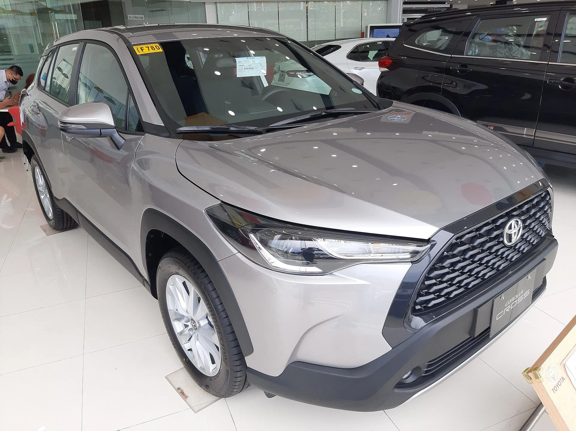 Toyota Corolla Cross prata em showroom, vista dianteira três-quartos