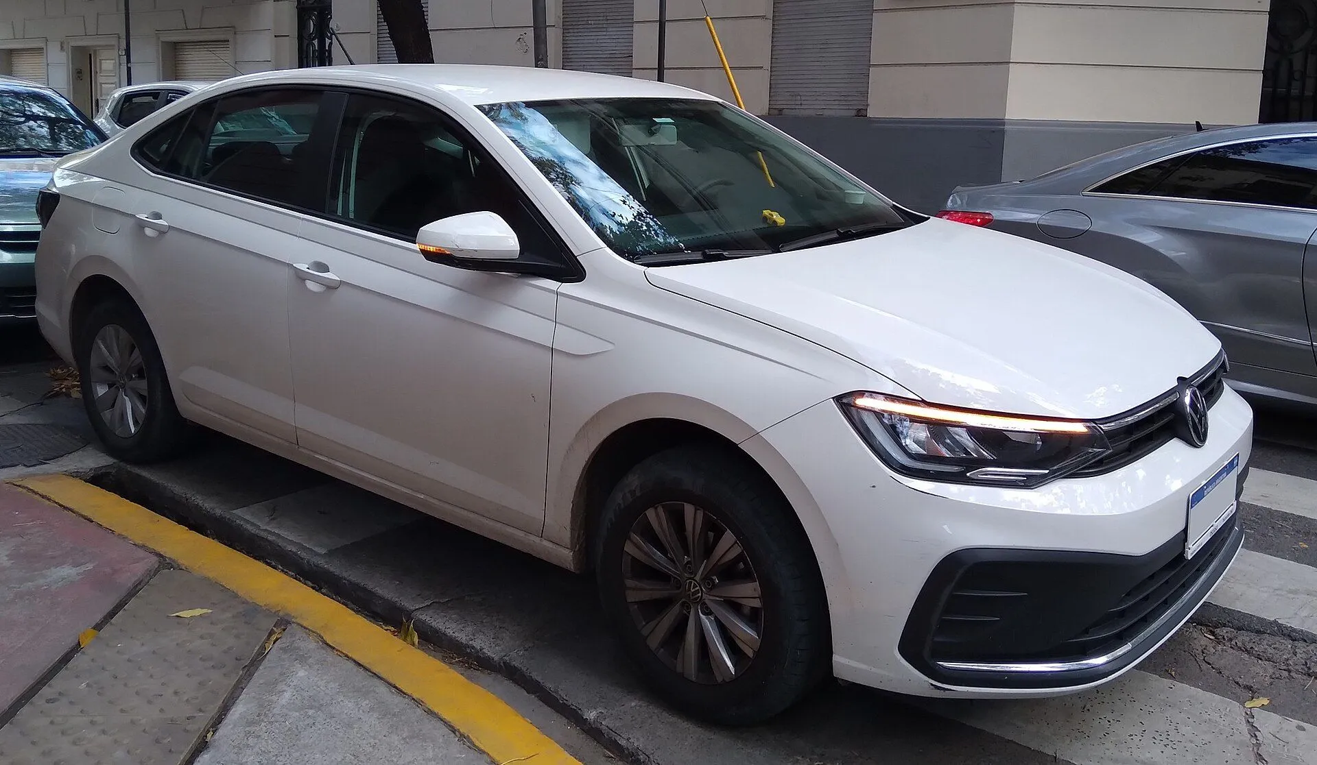 Volkswagen Virtus branco da linha reestilizada estacionado na rua, vista dianteira três-quartos